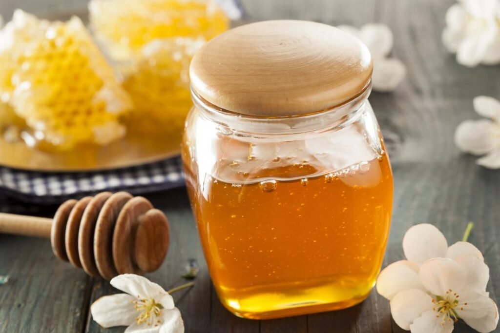 Made honey 100% pure in a glass jar with natural golden texture